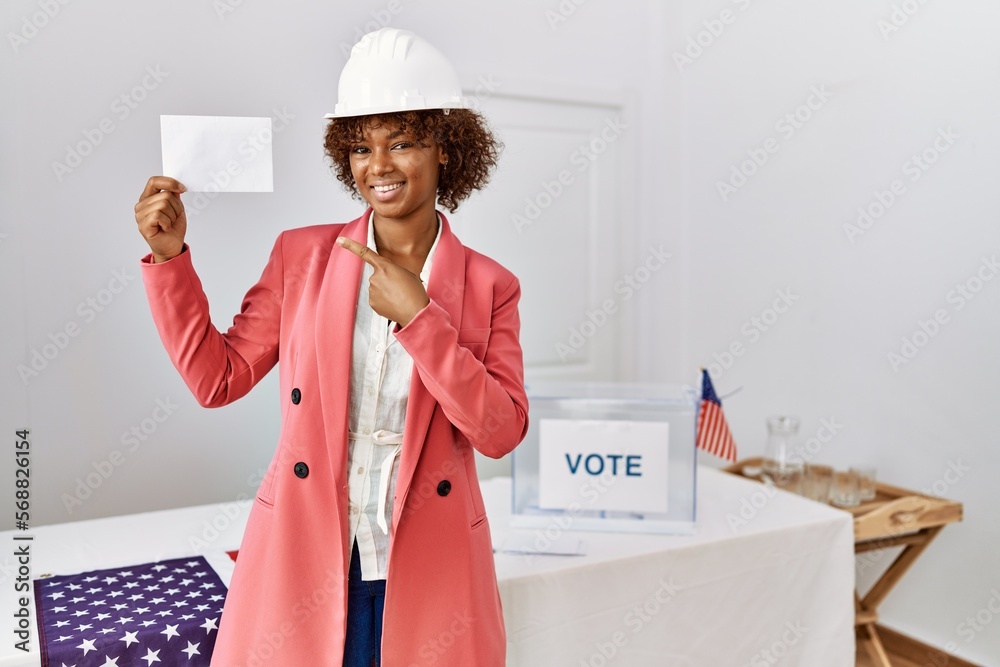 Poster Young african american architect woman at political election holding envelope smiling happy pointing with hand and finger