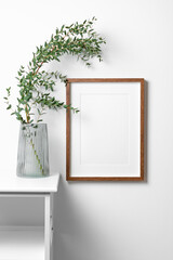 Wooden frame mockup on white wall in minimalistic interior