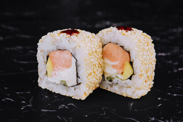 Japanese sushi rolls with salmon on black