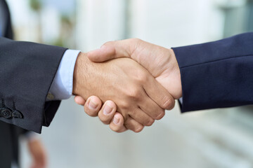 Two hispanic men business workers shake hands at street