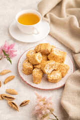 Traditional turkish delight (rahat lokum) with cup of green tea on a gray concrete background, side view, close up.
