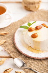 Fototapeta premium Ricotta cheese with honey and almonds on white wooden. side view, selective focus.