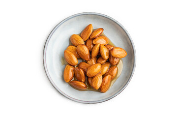 Almonds with honey isolated on white. top view, close up.