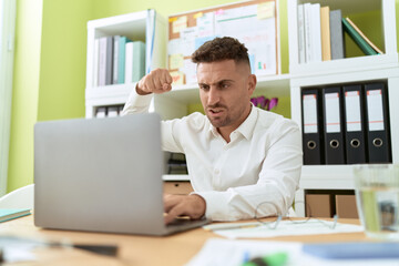 Fototapeta premium Young hispanic man business worker angry screaming at office