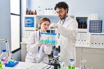 Man and woman scientist partners holding test tubes at laboratory