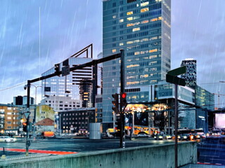 rain in city  modern building windows carrs traffi ight pedestrian with umbrellas walk urban life style
