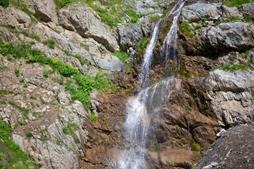 Beautiful waterfall in the mountains. Water flows down from the mountains.