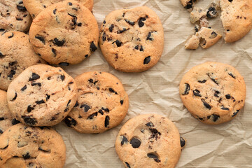 Cookies with pieces of chocolate on craft paper. Close-up, top view, flat lay
