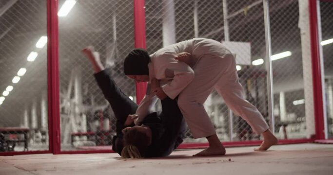 Female fighters during grappling training in gym