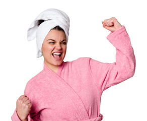 Young caucasian woman in bathrobe isolated raising fist after a victory, winner concept.