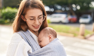 Mother and son sleeping baby standing at street