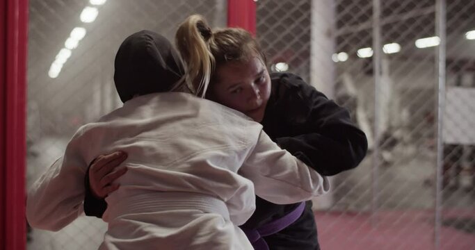 Female fighters clinching during grappling training