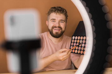 Bearded man professional beauty make up artist vlogger or blogger recording makeup tutorial to share on website or social media. - obrazy, fototapety, plakaty