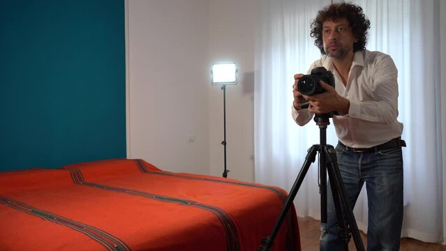 Italy, Milan - Real estate photographer man taking professional pictures and video of the bedroom for real estate agency - home staging to sell the house - renting a home for tourist  traveller 