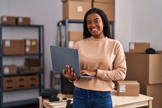 Young African American With Braids Working At Small Business Ecommerce With Laptop Smiling With A Happy And Cool Smile On Face. Showing Teeth.