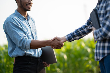 Handshake two farmer with crops field background. The concept of the agricultural business. farmer...