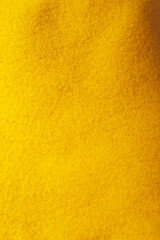 Obraz premium Autumn concept - plush yellow background. Knitted fabric texture, fleece fabric, inside of hoodie.