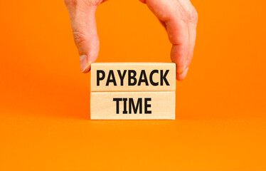 Payback time symbol. Concept words Payback time on wooden blocks. Beautiful orange table orange background. Businessman hand. Business and payback time concept. Copy space.