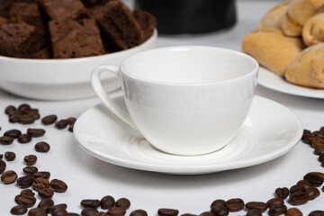 Empty coffee ceramic cup with chocolate cake and coffee beans on a white background