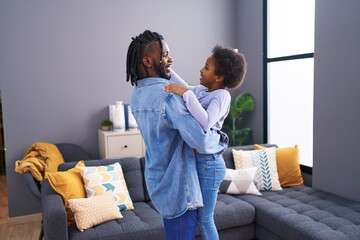 Father and daughter smiling confident dancing at home