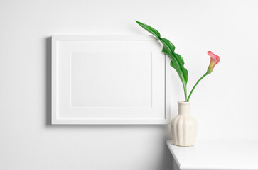 Landscape artwork frame mockup in white interior with calla flower in vase