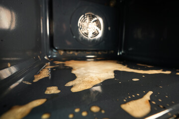 Close up view of the dirt and grease while cleaning an electrical oven with chemical solutions. Wide photo inside the oven.