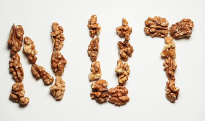 Concept image for nuts as a healthy snack during the day or breakfast. Nut word made from a lot of nuts fruits against white background. 