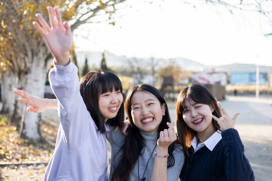 Happy Lifestyle Of A Group Of Young Asian Women Playing With Each Other Outside. The 3 Women Make Funny Gestures Or Expressions To The Camera, Joking. Concept Of Sharing Stories In Social Networks