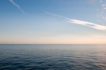 Cielo azzurro degradante con nuvole e mare calmo