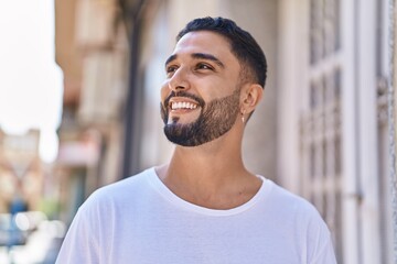 Obraz premium Young arab man smiling confident looking to the side at street