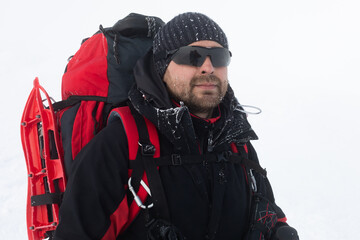Hiker with a backpack and snowshoes on a winter day