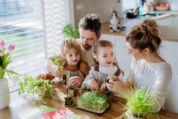 Happy family planting herbs together at spring.