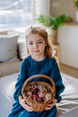 Portrait of little girl holding basket with easter eggs.
