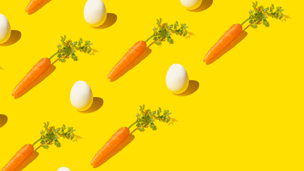 Trendy pattern made of carrots and eggs on bright yellow background with diagonal copy space. Balanced diet concept.
