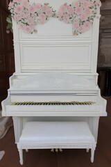 Fototapeta na wymiar Elegant old white piano with broken keys decorated with flowers. Classic interior - generative ai 