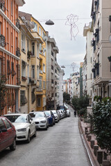 Naklejka na ściany i meble Typical Istanbul street. Parking on the one side of the street.