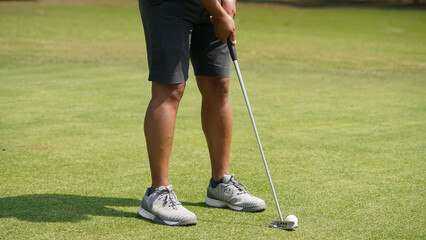 Golfer putting ball on the green golf