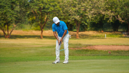 Golfer putting ball on the green golf