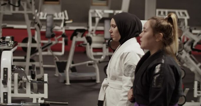 Female wrestlers walking and talking in gym