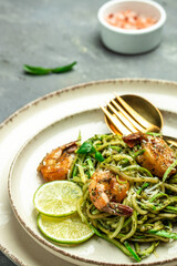 Pasta spaghetti zucchini basil pesto sauce and grilled shrimp, Vegetarian vegetable pasta, Food recipe background. Close up