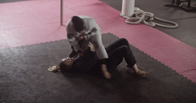 Women practicing grappling holds on floor