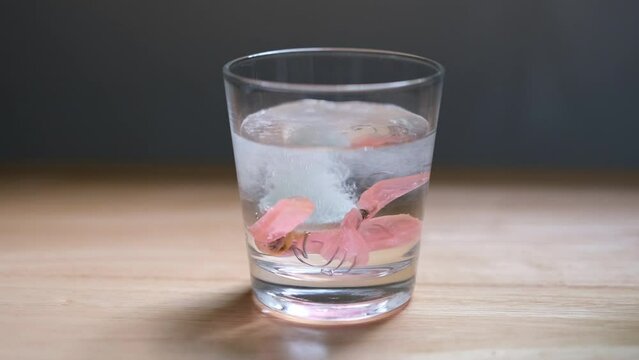 effervescent tablets into clear glass with retainer to remove plaque and bacteria for cleaning.