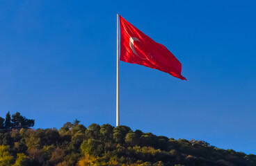 National flag of Turkey flies with the blue sky in the background