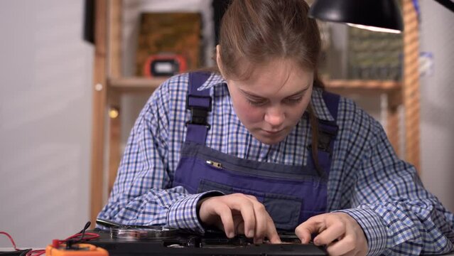 Woman engineer repairs laptops installed motherboard install random access memory ram memory in computer workshop.