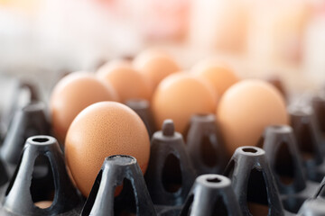 Naklejka na ściany i meble Brown eggs in egg box with light flare,close-up