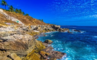 Fototapeta na wymiar Beautiful rocks cliffs view waves at beach Puerto Escondido Mexico.
