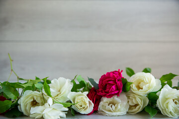 background of many red roses on a light wooden
