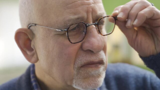 The old man looks at himself in the mirror, looks at his wrinkled and chalky skin and is unhappy.
The old man looking at himself in the mirror doesn't like his wrinkled face, he doesn't feel well beca