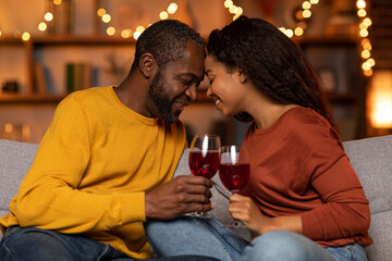 Romantic african american lovers cuddling on couch at home
