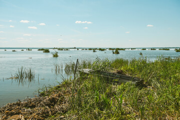small green wooden boat on the river bank, summer sunny day, Russia, Rostov Veliky